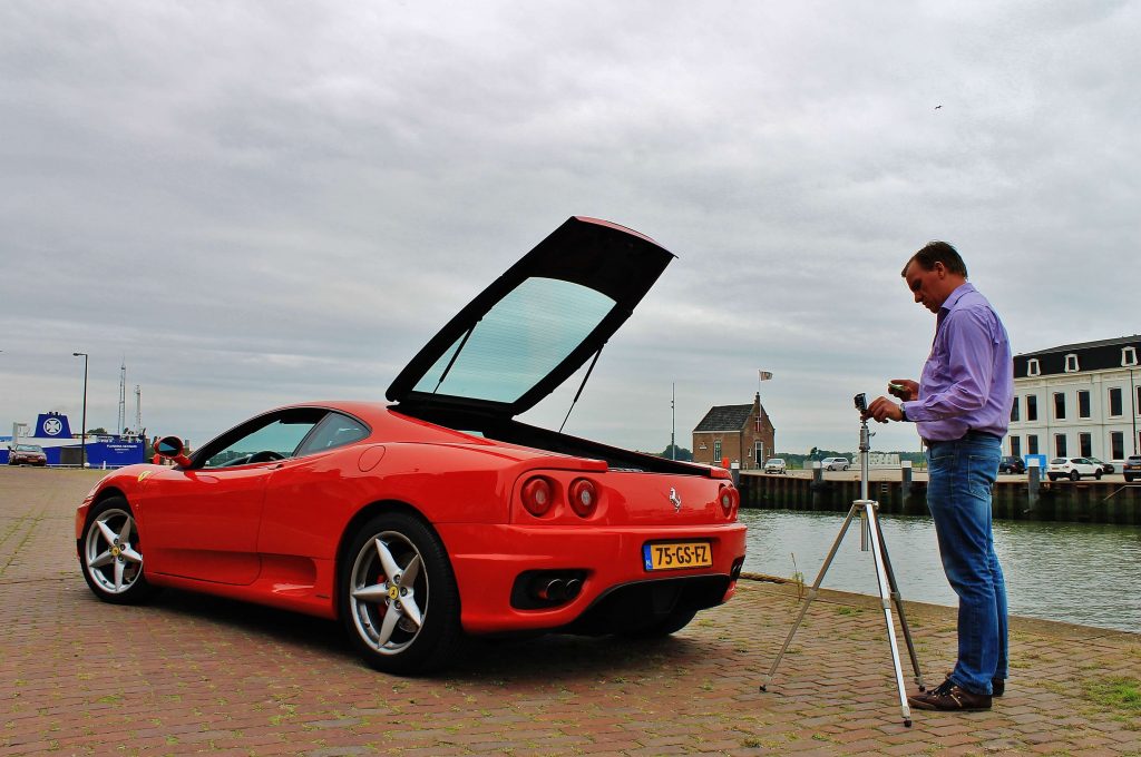 Man maakt met behulp van een statief een foto van een Ferrari 360 Modena op een kade in Maassluis, zoals carspotters ook kunnen doen.