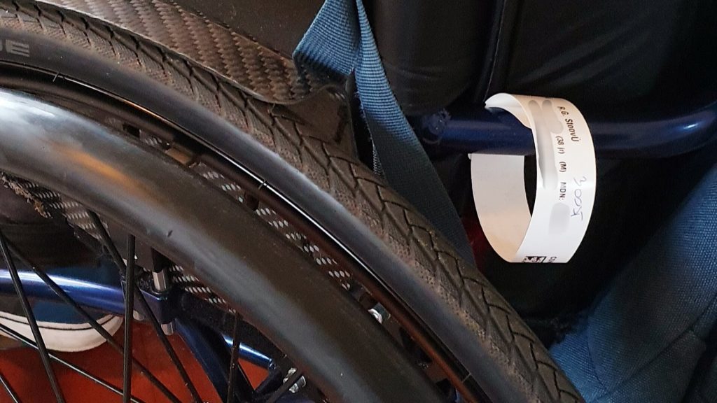 Polsbandje voor de operatie in het ziekenhuis vastgemaakt aan mijn rolstoel