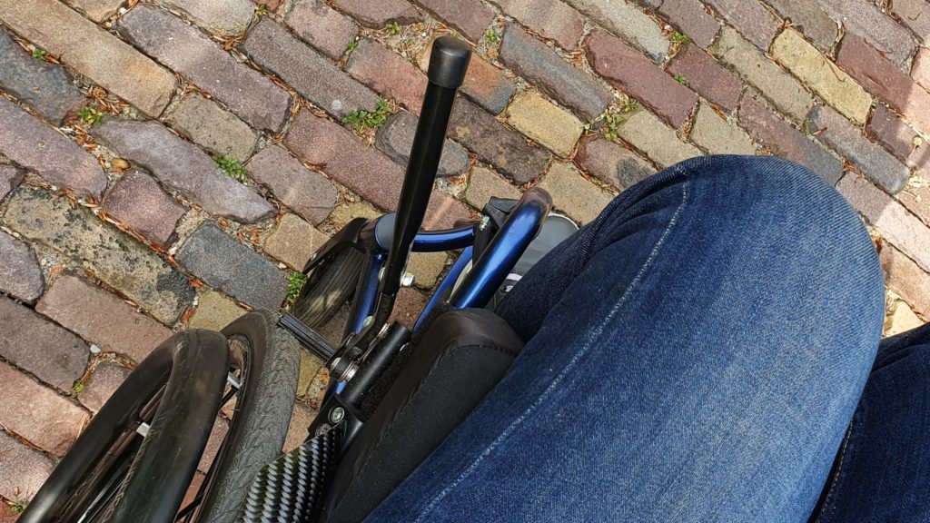 afbeelding van uitgeklapte remverlengers bij een rolstoel die op de rem staat
