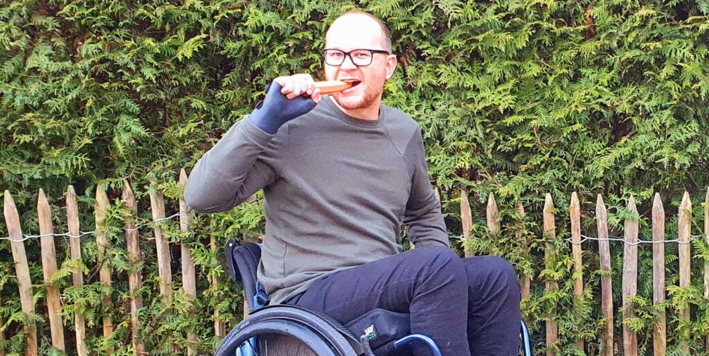 photo of a wheelchair user taking a bite of a carrot indicating how crazy it is when you unsolicitedly recommend a carrot diet to a glasses-user
