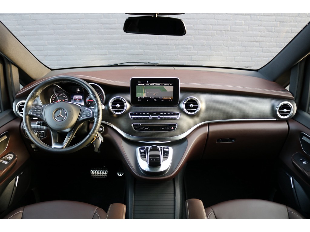 Foto van het interieur van een Mercedes-Benz V-klasse met daarin zichtbaar het bruine leer, carbonlook dashboard, Avantgarde stylingpakket, navigatiesysteem, maar nog zonder aanpassingen tot rolstoelbus.