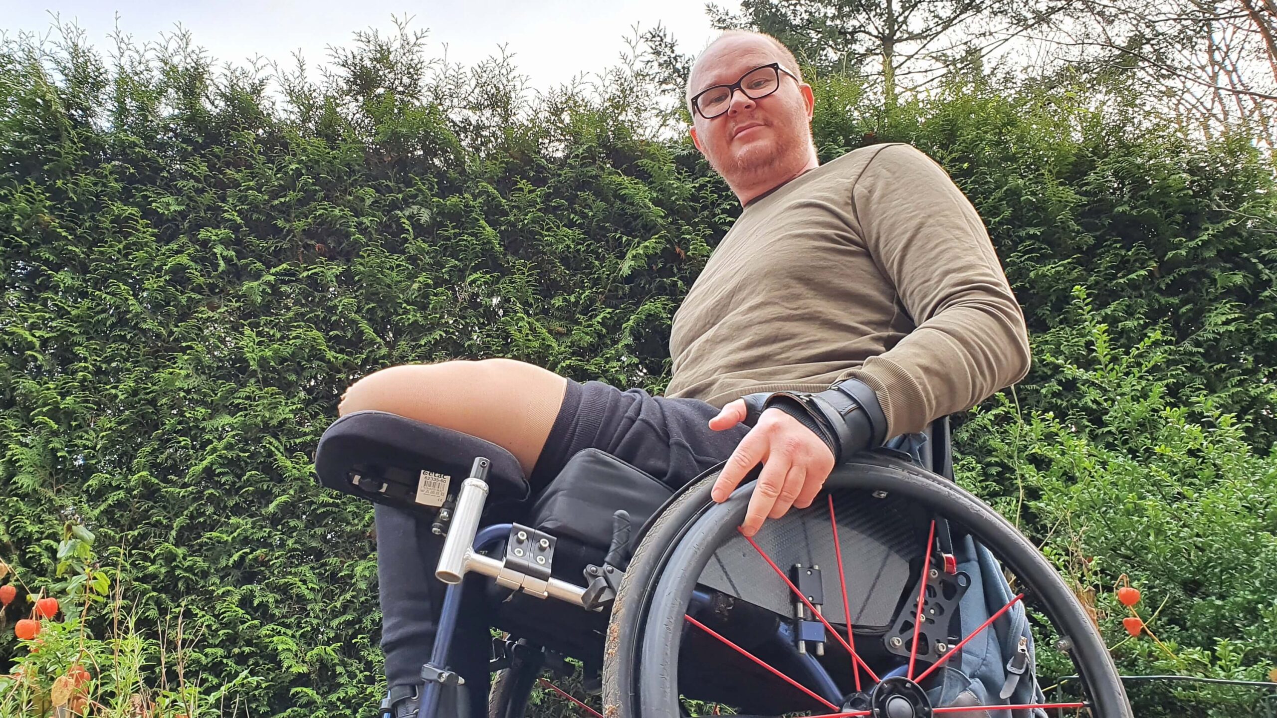 afbeelding van RaGaSto in een rolstoel met daarop een stompsteun waarop hij zijn stomp in een stompkous legt ter voorkoming van een contractuur of dwangstand na amputatie van zijn linker been