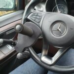 Afbeelding van een driepotige stuurspalk op een stuur van een Mercedes-Benz.