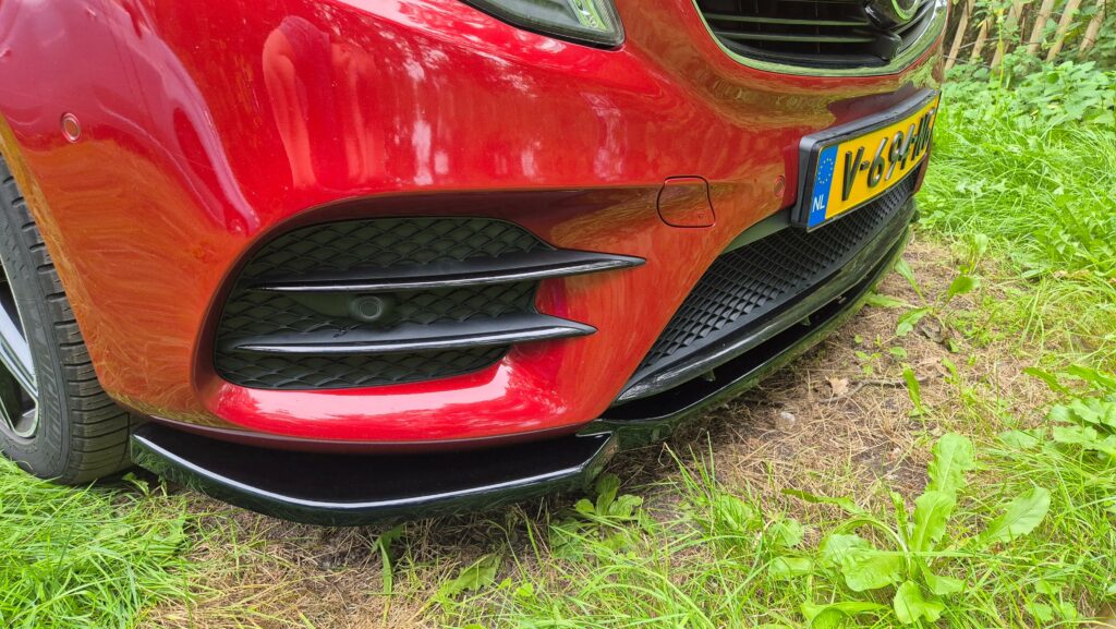 Close-up foto van de Maxton Design front splitter gemonteerd op een rode Mercedes-Benz V-Klasse AMG-Line.