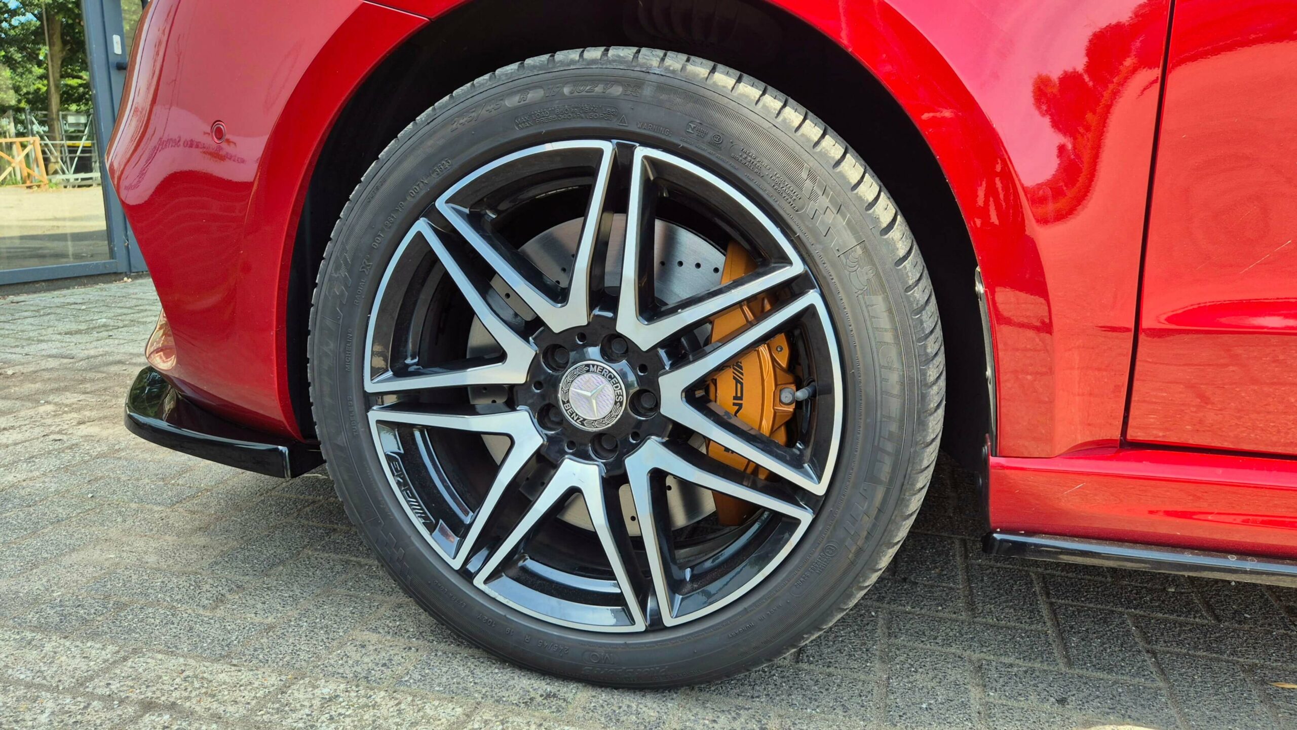 Foto van de W447 big brake kit gemonteerd op een hyacintrode Mercedes-Benz V-Klasse. De grotere remmen zijn in dit geval gemonteerd op een Mercedes rolstoelbus die voorzien is van een AMG-Line exterieurpakket en een Maxton Design spoilerset. De remmenupgrade is zichtbaar door de 19 inch AMG velgen.