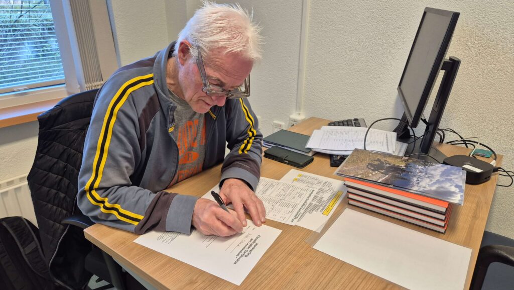 Afbeelding van classifier Kees van Breukelen die de formulieren invult bij het bepalen van de handicapklasse voor handbikers. 